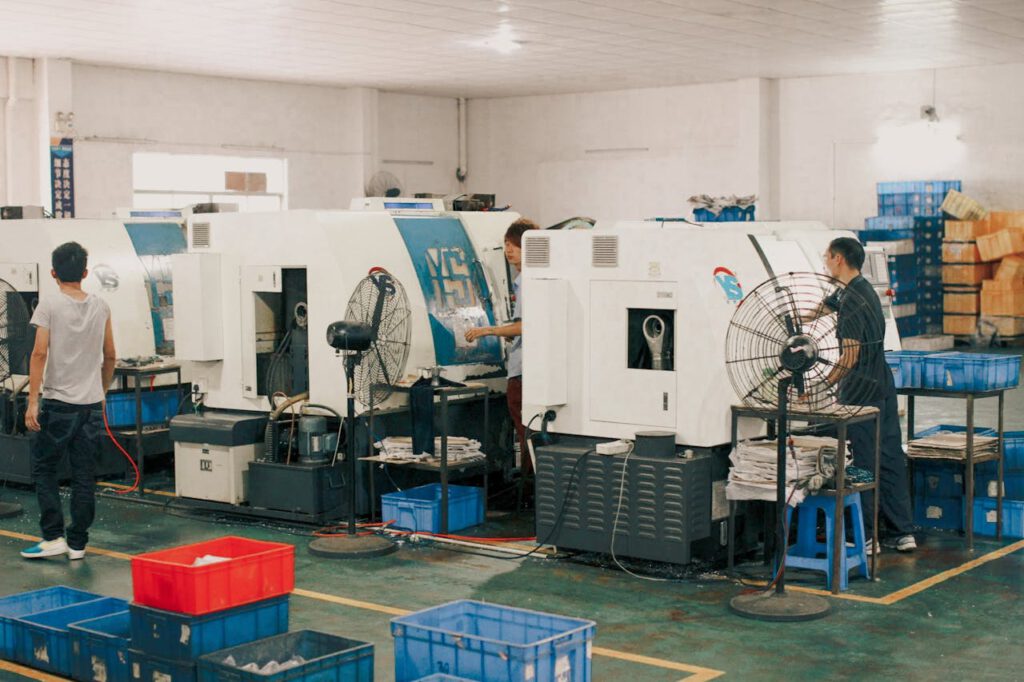 pexels-photo-11765539 Workers operating machinery in an industrial factory setting, showcasing manual labor and production.